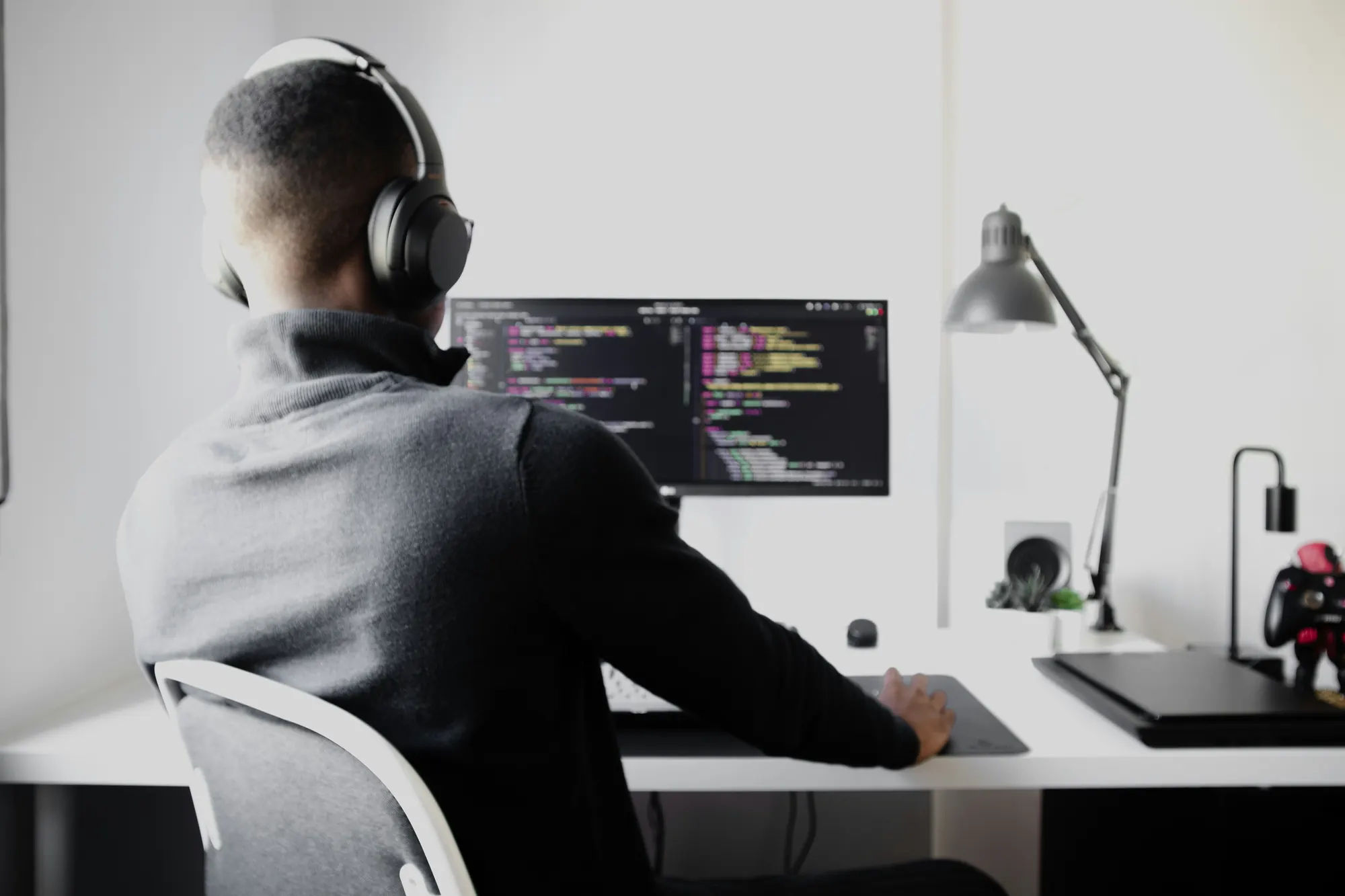 Développeur au casque travaillant sur du code devant son écran